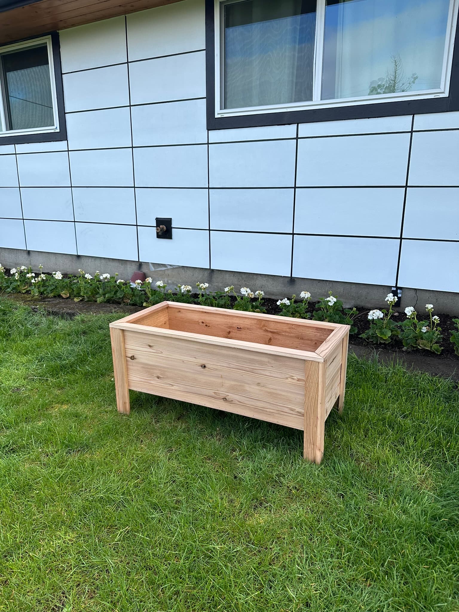 Cedar raised planter with medium legs, angled view showing natural wood grain